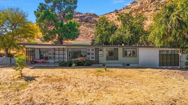 view of front of property with a mountain view and a front lawn