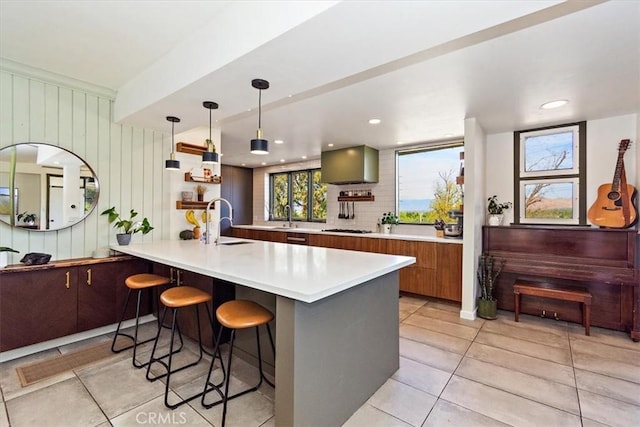 kitchen with sink, a breakfast bar area, decorative light fixtures, gas cooktop, and kitchen peninsula