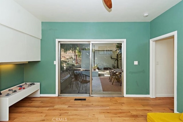 doorway to outside with ceiling fan and light wood-type flooring