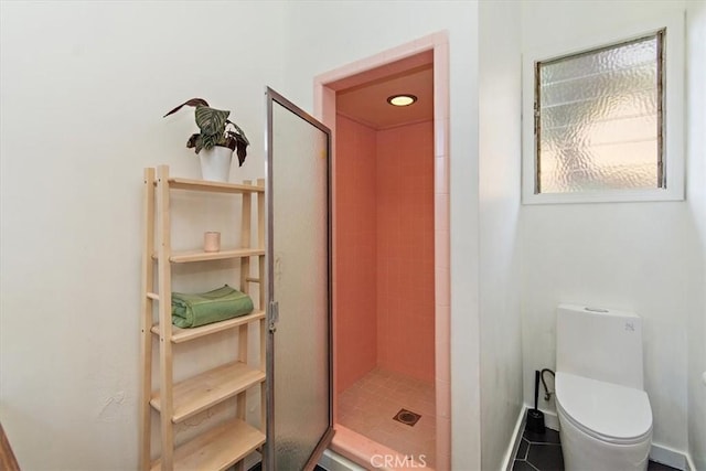 bathroom with toilet, tile patterned flooring, and a shower with door