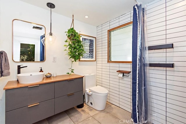 bathroom featuring tile walls, tile patterned flooring, vanity, walk in shower, and toilet