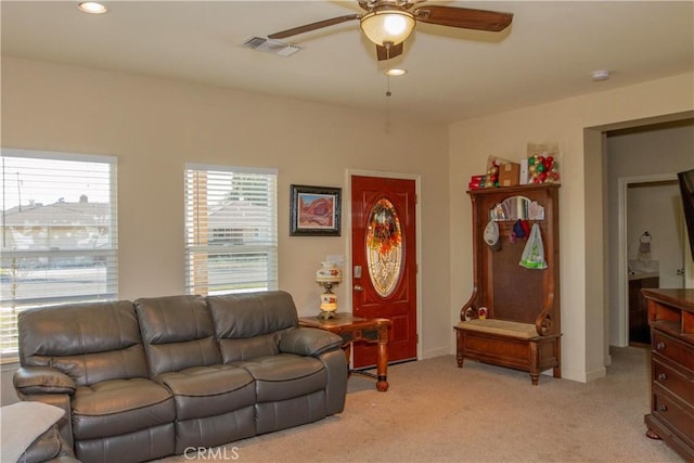 carpeted living room with ceiling fan