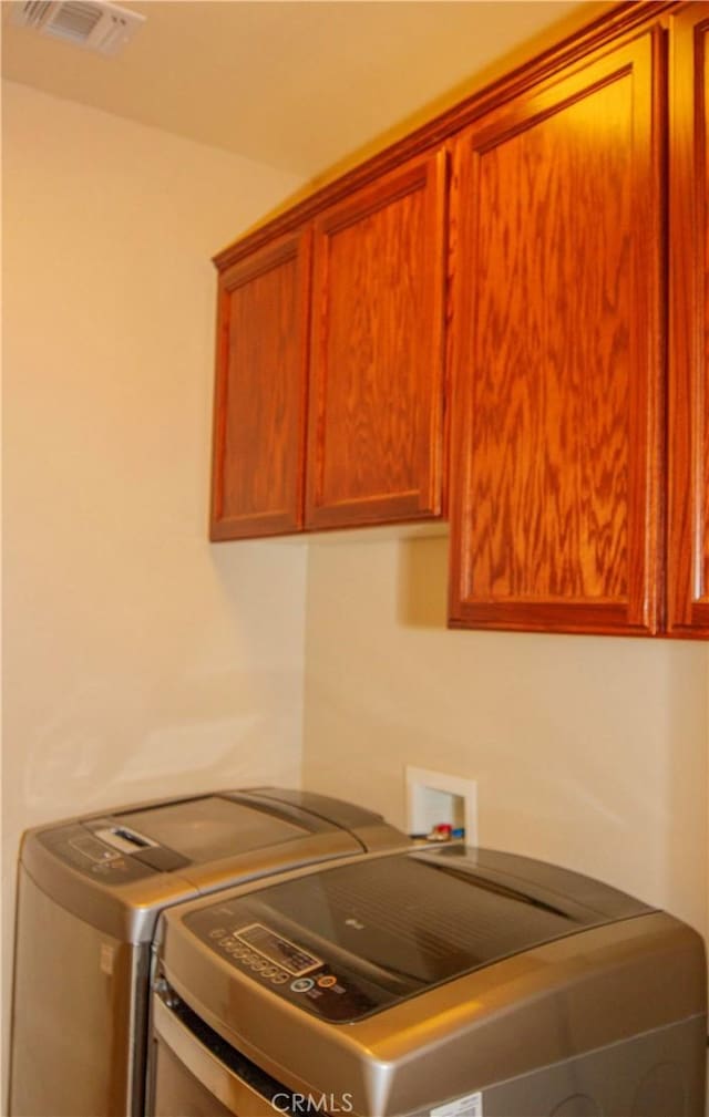 washroom with cabinets and washer and clothes dryer