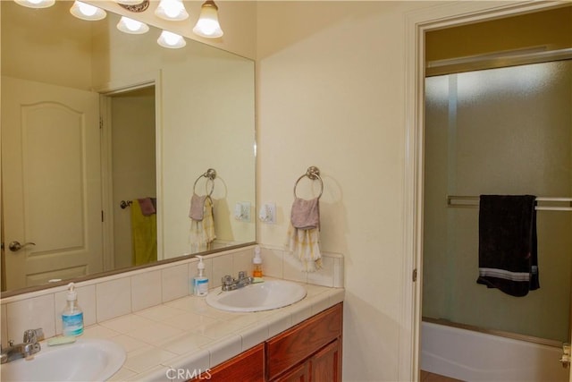 bathroom featuring vanity and shower / bath combination with glass door