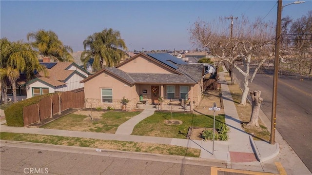 view of front of property featuring a front yard and solar panels