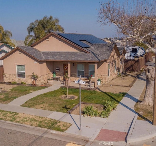 view of front of home featuring a front yard and solar panels