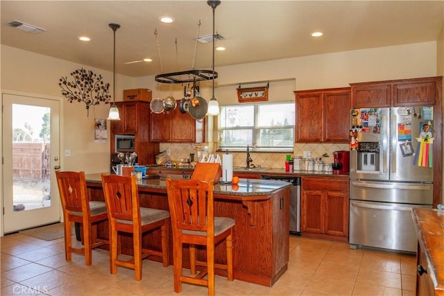 kitchen with a kitchen island, a breakfast bar, a wealth of natural light, backsplash, and stainless steel appliances