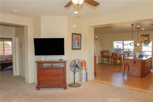 living room with a wealth of natural light, light colored carpet, and ceiling fan