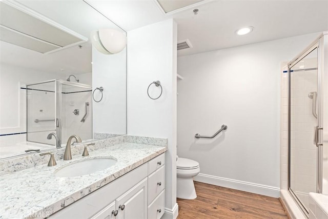 bathroom featuring a shower with door, vanity, hardwood / wood-style floors, and toilet