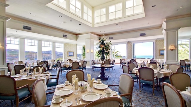 dining area featuring crown molding, a mountain view, decorative columns, and a high ceiling