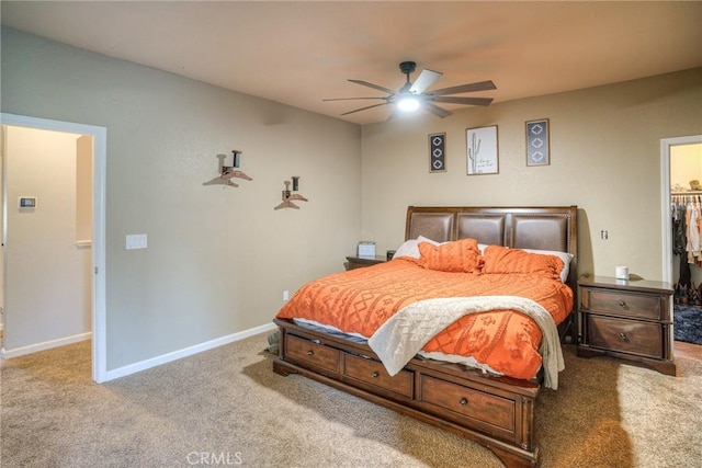 bedroom with light carpet, a spacious closet, and ceiling fan