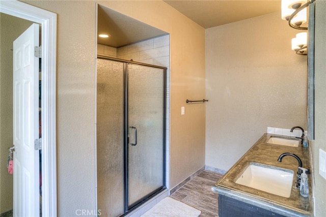 bathroom featuring walk in shower, wood-type flooring, and vanity