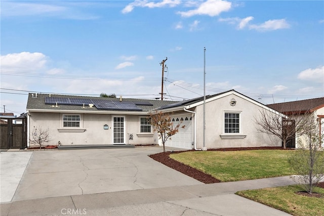 ranch-style house featuring a garage, a front lawn, and solar panels