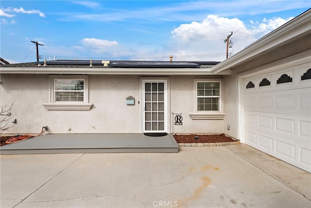 property entrance featuring a garage and solar panels