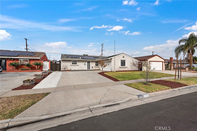 ranch-style home featuring a garage, a front yard, and solar panels