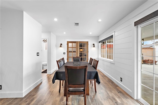 dining space with hardwood / wood-style flooring and french doors