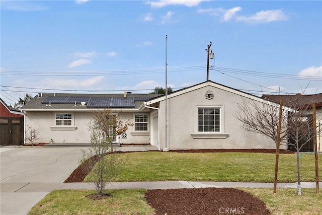 ranch-style home featuring a front yard and solar panels