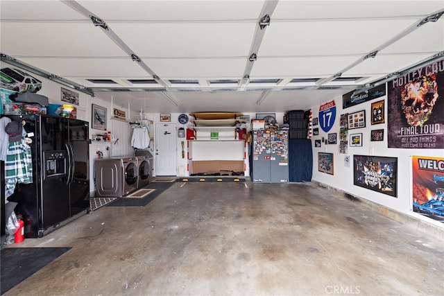 garage with black fridge and washing machine and clothes dryer