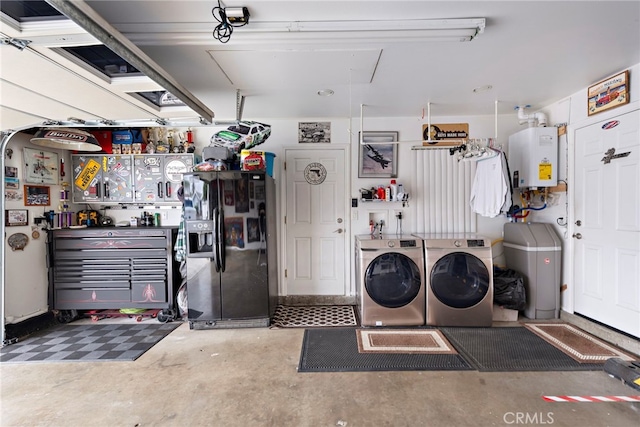 garage with black fridge, independent washer and dryer, water heater, and a workshop area