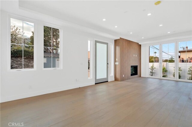 unfurnished living room featuring a large fireplace and light hardwood / wood-style floors