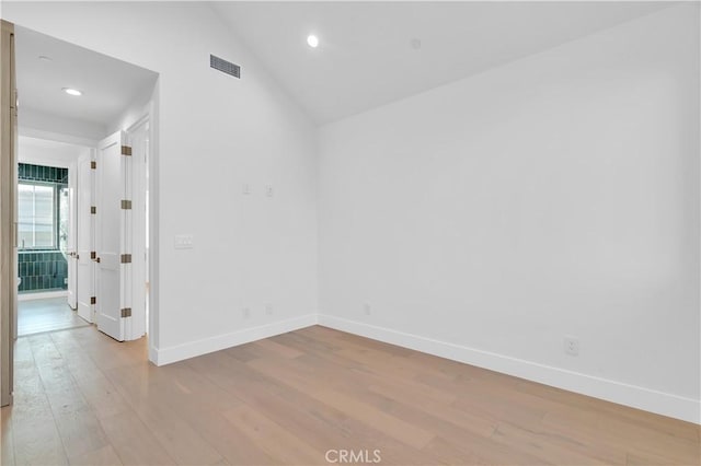 empty room featuring lofted ceiling and light wood-type flooring