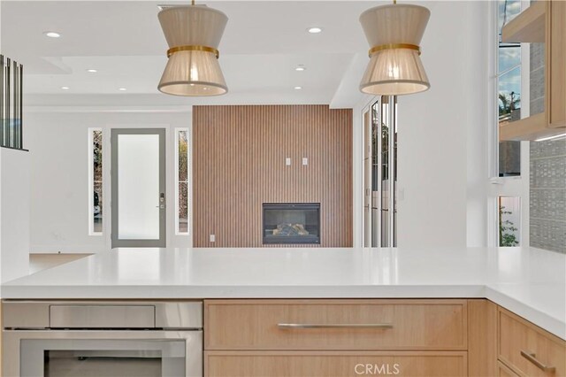 kitchen with light brown cabinetry and oven