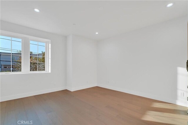 unfurnished room with hardwood / wood-style flooring