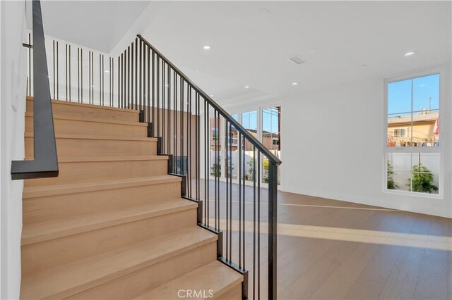 staircase with hardwood / wood-style floors