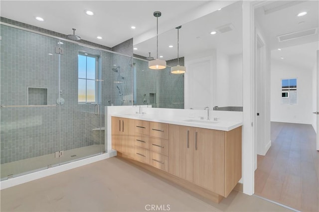 bathroom with a shower with door and vanity