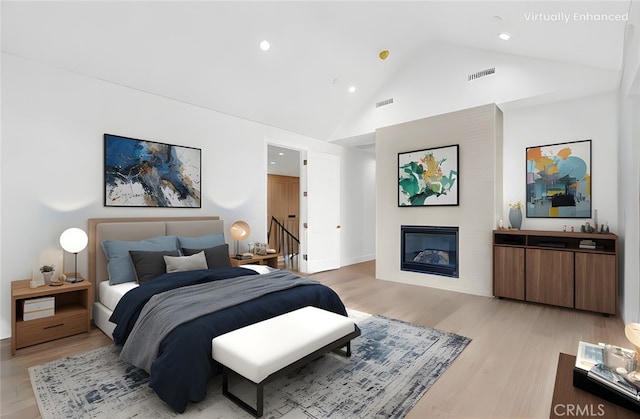 bedroom with high vaulted ceiling and light wood-type flooring