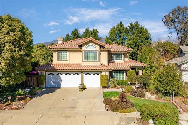 mediterranean / spanish-style home with a garage