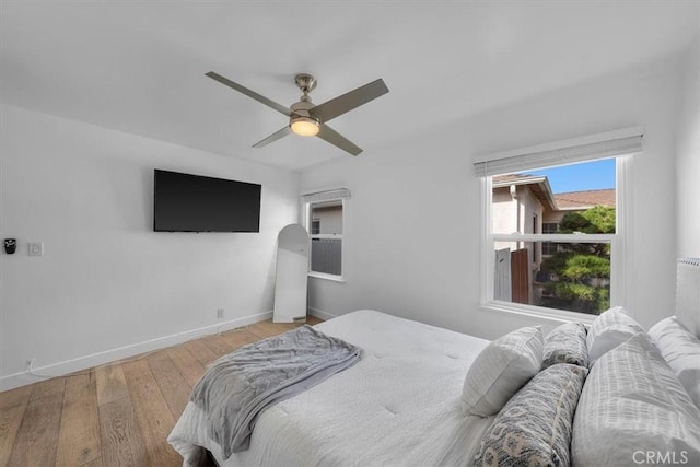 bedroom with baseboards, wood finished floors, and ceiling fan
