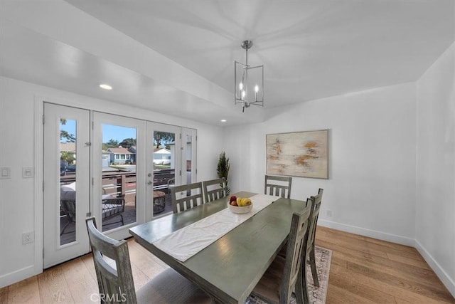 dining area featuring a notable chandelier, light hardwood / wood-style flooring, and french doors