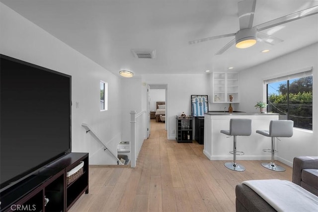 bar with ceiling fan, plenty of natural light, and light hardwood / wood-style floors