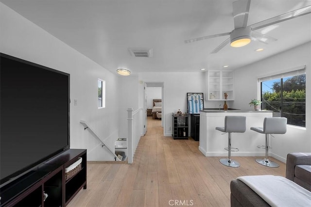 kitchen featuring plenty of natural light, light wood-style flooring, a kitchen bar, and visible vents