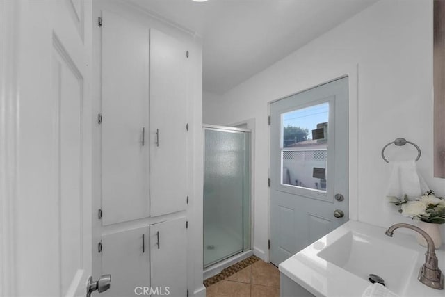 bathroom with a stall shower, tile patterned flooring, and a sink