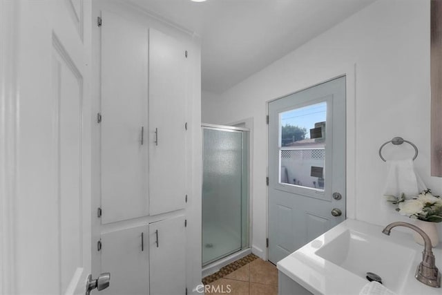 full bathroom with tile patterned floors, a sink, and a shower stall