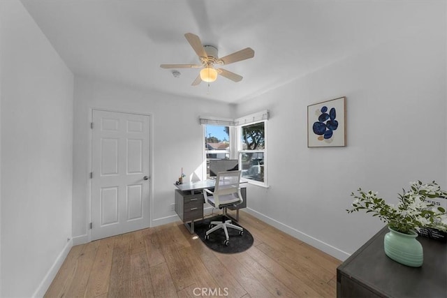 office featuring light wood finished floors, a ceiling fan, and baseboards