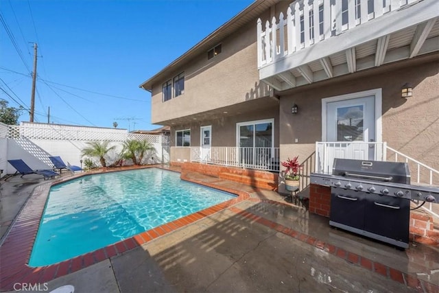 view of swimming pool featuring a patio area, a fenced backyard, grilling area, and a fenced in pool