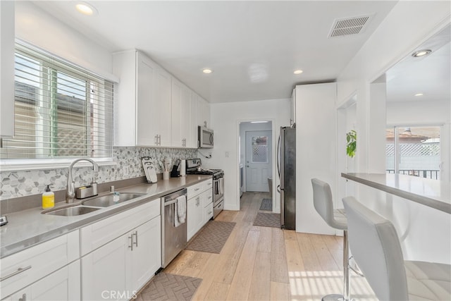 kitchen with white cabinets, visible vents, appliances with stainless steel finishes, and a sink