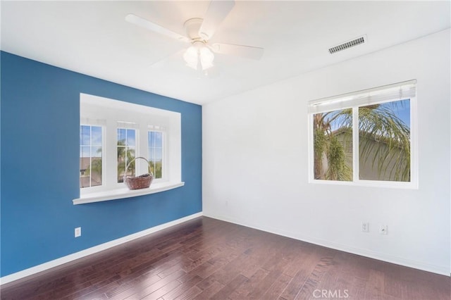 empty room with dark hardwood / wood-style floors and ceiling fan