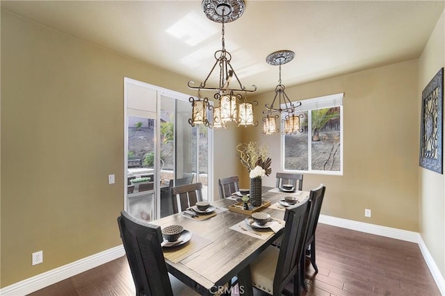 dining area with dark hardwood / wood-style floors and an inviting chandelier