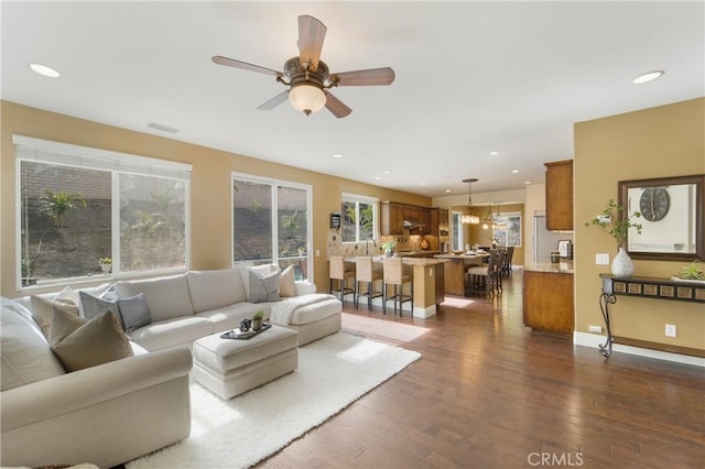 living room featuring ceiling fan and dark hardwood / wood-style floors