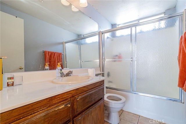 full bathroom with toilet, tile patterned floors, bath / shower combo with glass door, and vanity