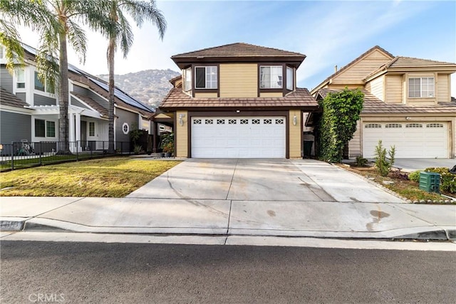 view of property with a garage, a mountain view, and a front yard