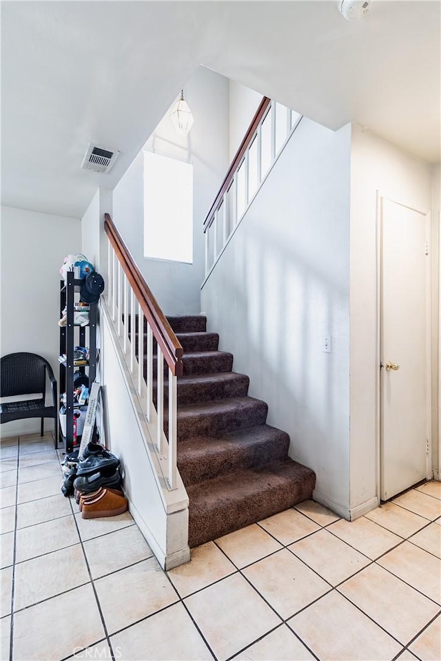 staircase featuring tile patterned floors