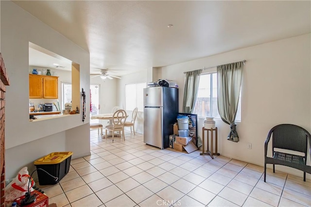 kitchen featuring ceiling fan, light tile patterned floors, and stainless steel refrigerator