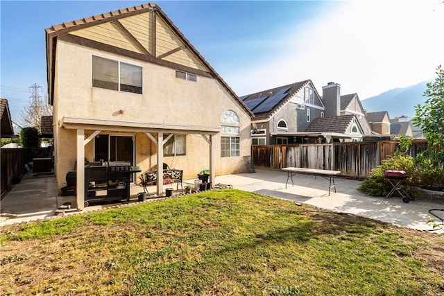 back of house with a yard and a patio area