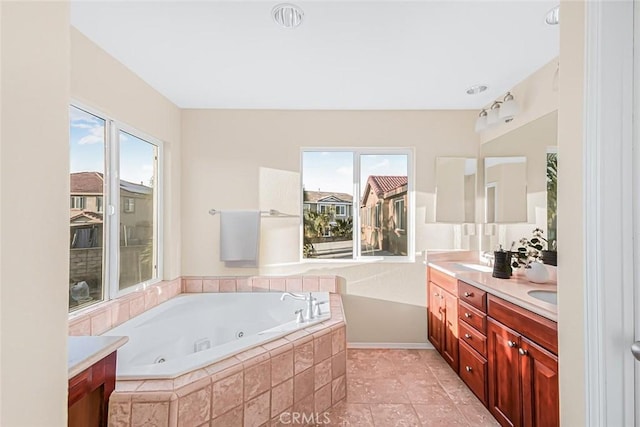 bathroom with vanity, tile patterned flooring, and tiled tub