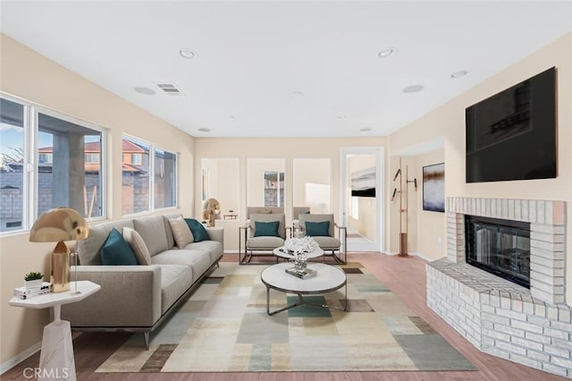 living room with a fireplace and light wood-type flooring